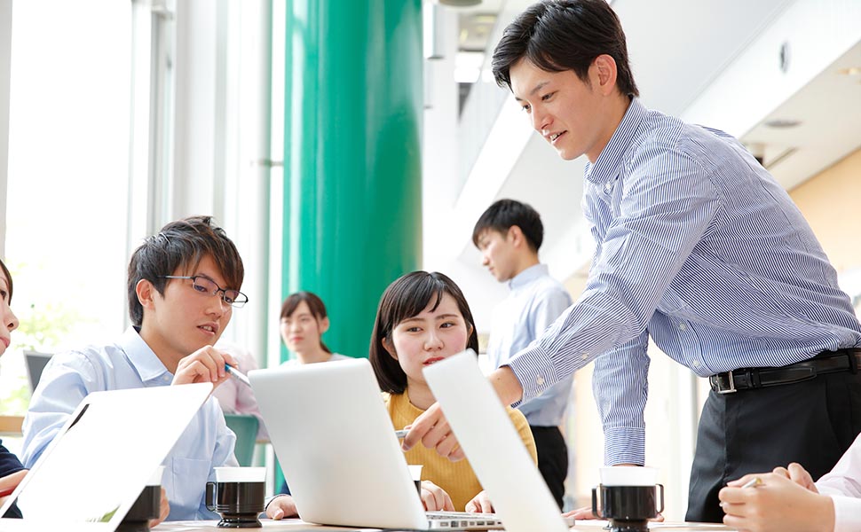 研究室で学生を指導する教員